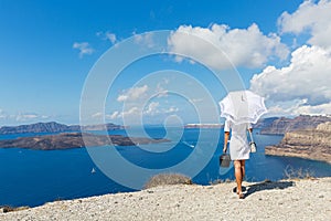Woman with white umbrella and sea