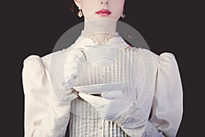 Woman in white victorian era clothes with cup of tea