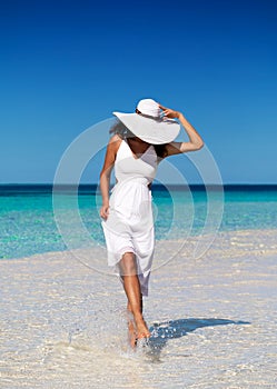 Woman in white walking over a sandbank