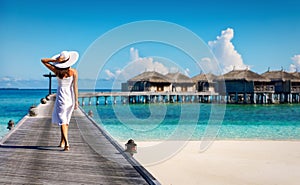 Woman in white walking over a wooden jetty