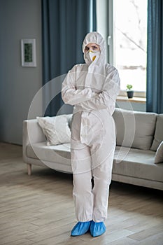 Woman in white workwear and protective eyeglasses looking ready to work