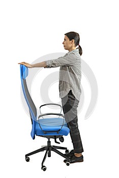 Woman who adjusts his ergonomic chair in the office