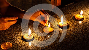 A woman who is lighting five Thai styled candles during Loy Krathong or Yeepeng festival in Chiang Mai