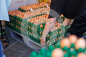 Woman who proceeds to Lift Multiple Egg Packs photo