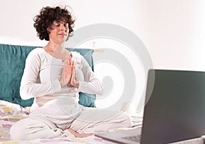 Woman who relaxes practicing yoga and meditation at home, yoga student who follows online lessons in quarantine, simple position