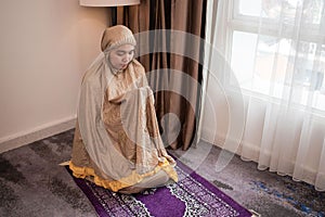 A woman who was praying on a prayer mat