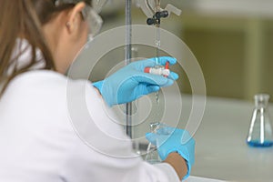 The woman whoâ€™s the scientist is demonstrate the titration technique