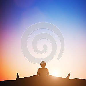 Woman in wide angle bend yoga pose meditating at sunset. Zen