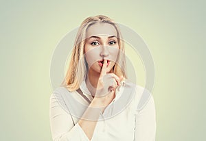 Woman wide eyed asking for silence or secrecy with finger on lips