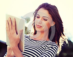 Woman, wind and smile with tablet in nature for social media, blog or digital communication. Happy, female person and