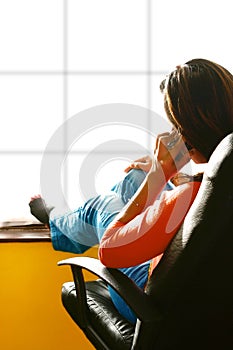 Woman by window on cell phone