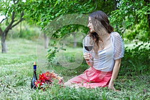 Woman with wine, woman with glass of wine, woman drinking red wine in the garden