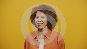 Woman Wink and Smile on Yellow Background