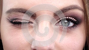 Woman winking. Blue eyes. Closeup