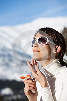 Woman in winter applying protective cream