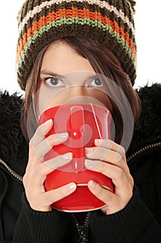 Woman with winter cap drinking something hot