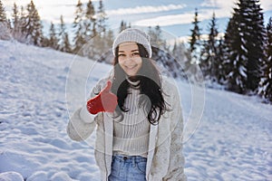 Woman in Winter Clothes Thumbs Up in Front of Mountain Forest Outdoors