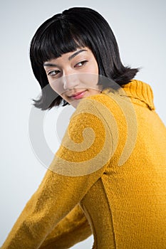 Woman in winter clothing posing against white background