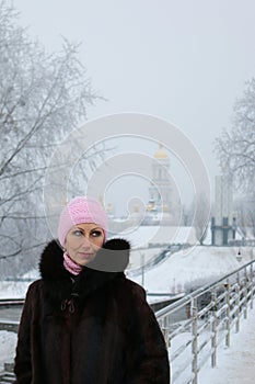 Woman on the winter footbridge looks mysteriously to the left