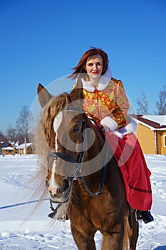 Woman in winter on a horse on a Sunny frosty day