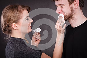 Woman wipe man face by hygienic tissue.