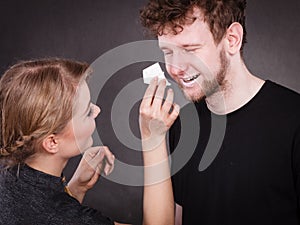 Woman wipe man face by hygienic tissue