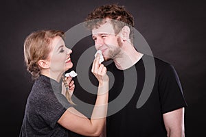 Woman wipe man face by hygienic tissue.