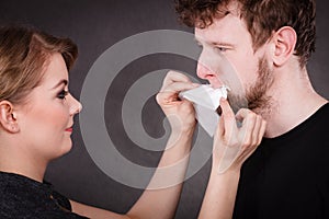 Woman wipe man face by hygienic tissue.