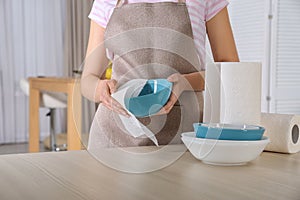 Woman wiping bowl with paper towel in kitchen