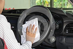 Woman wiping the car`s interior for cleanliness.
