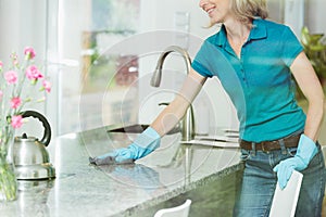 Woman wiping down kitchen countertop