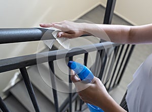 Woman wiping railings in staircase