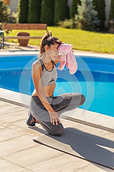 Woman wiping sweat using towel after workout