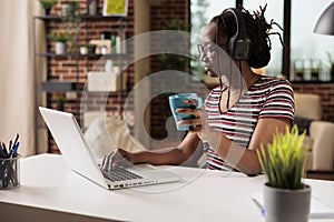 Woman in wireless headphones watching movie online on laptop