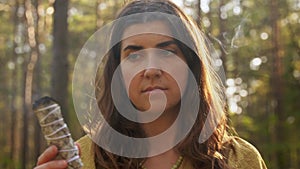 Woman or witch performing magic ritual in forest