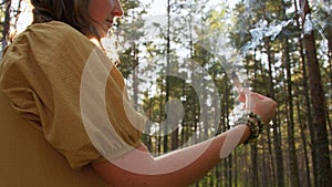 Woman or witch performing magic ritual in forest