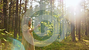 Woman or witch performing magic ritual in forest