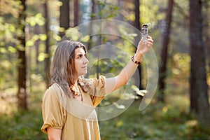 Woman or witch performing magic ritual in forest