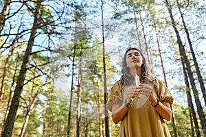 Woman or witch performing magic ritual in forest