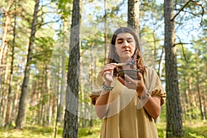 Woman or witch performing magic ritual in forest
