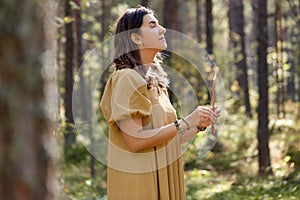 Woman or witch performing magic ritual in forest