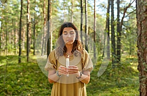 Woman or witch performing magic ritual in forest