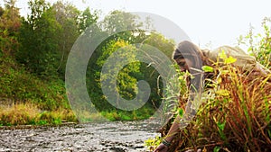 Woman or witch performing magic ritual on river