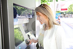 Woman withdrawing money from distributor photo