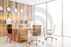Woman in wooden CEO office with clocks