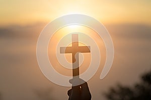 Woman with Wooden cross in hands praying for blessing from god on sunlight background, hope concept - Image