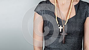 Woman with wooden crosses around her neck. Religion and belief