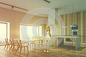 Woman in wooden kitchen corner with dining table