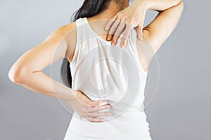 Woman wore white undershirt,hands holding her back in pain and waist .Health-care Concept.Selective focus