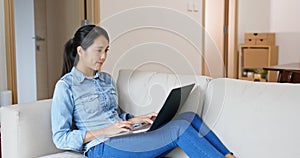 Woman work on computer and sit on sofa